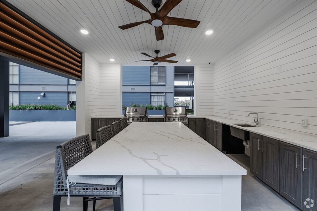 the kitchen has a large island with a marble countertop and a dining room table