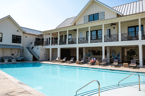 A large house with a pool in front.