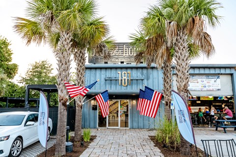 A building with the number 181 on it is flanked by two palm trees.