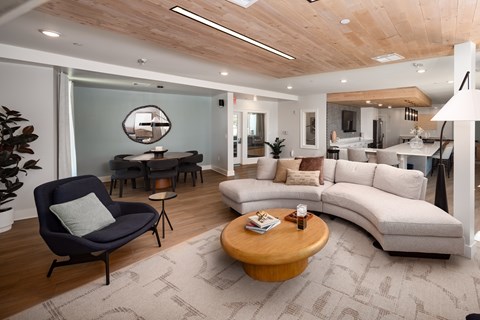 A modern living room with a dark blue chair and a wooden coffee table.
