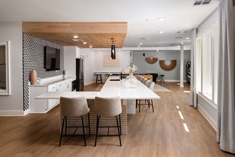 A modern dining room with a long table and chairs.
