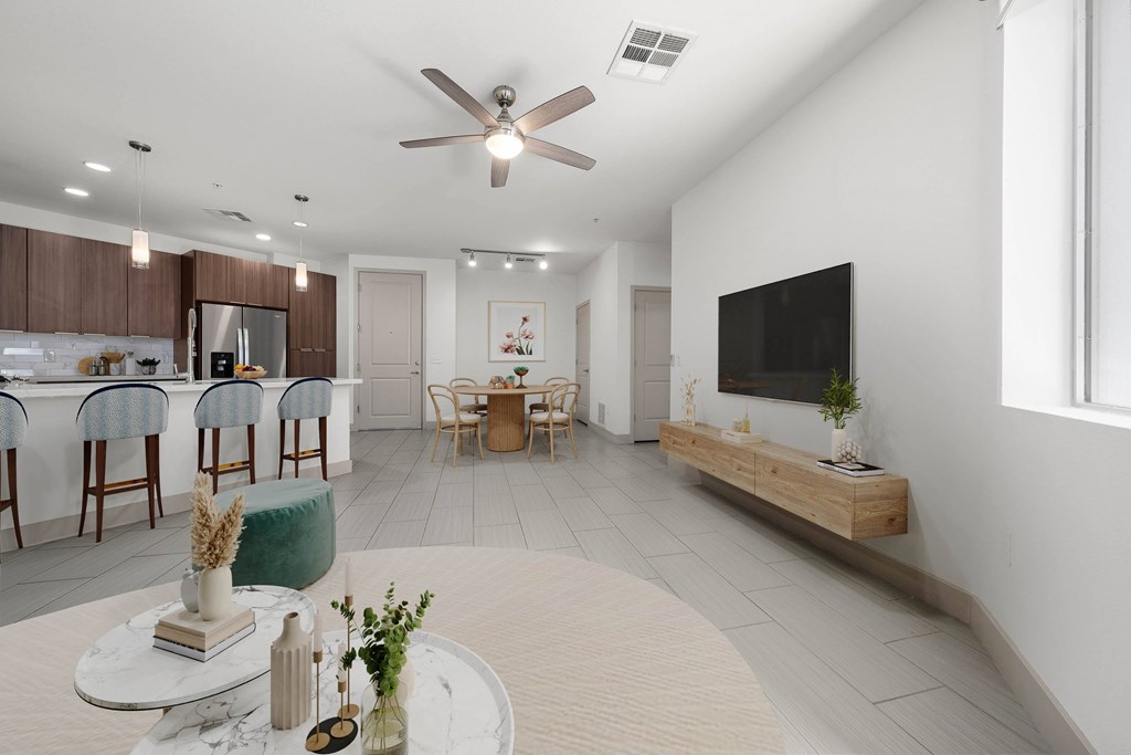 A modern living room with a dining area and a kitchen in the background.