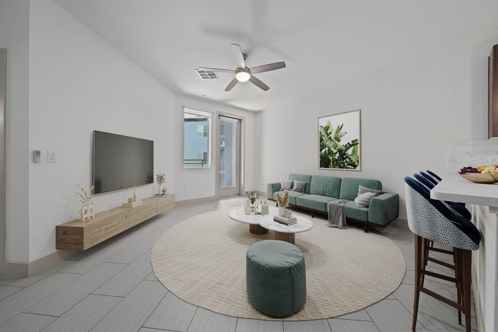 A living room with a grey sofa, a white coffee table, and a ceiling fan.