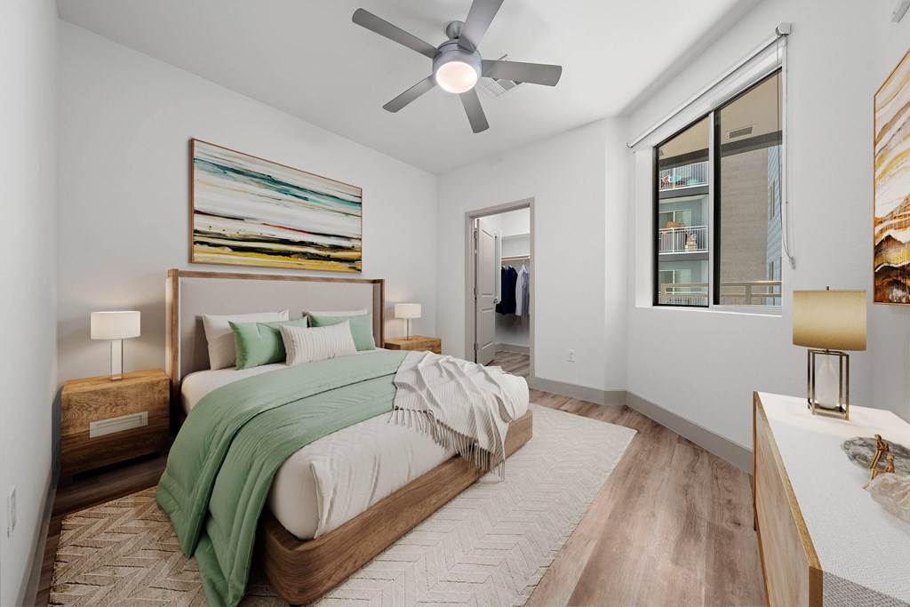 A bedroom with a large bed and a ceiling fan.