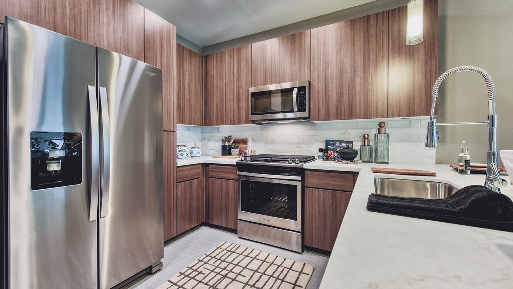 A modern kitchen with wooden cabinets and stainless steel appliances.