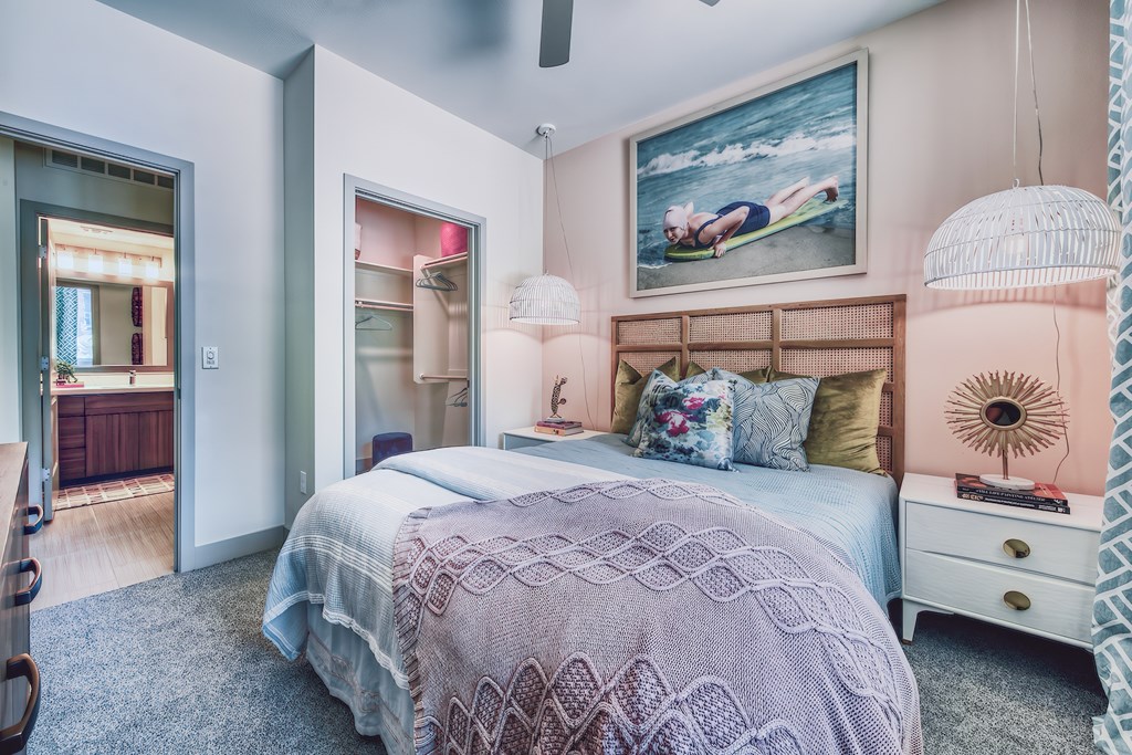 A bedroom with a bed, a dresser, and a painting on the wall.