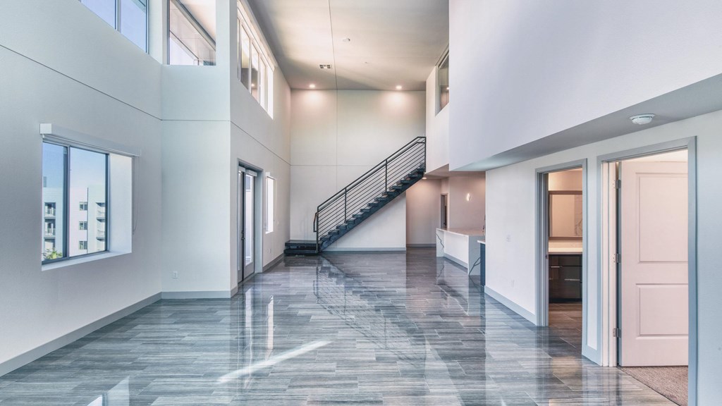 A spacious interior with a marble floor and a staircase.