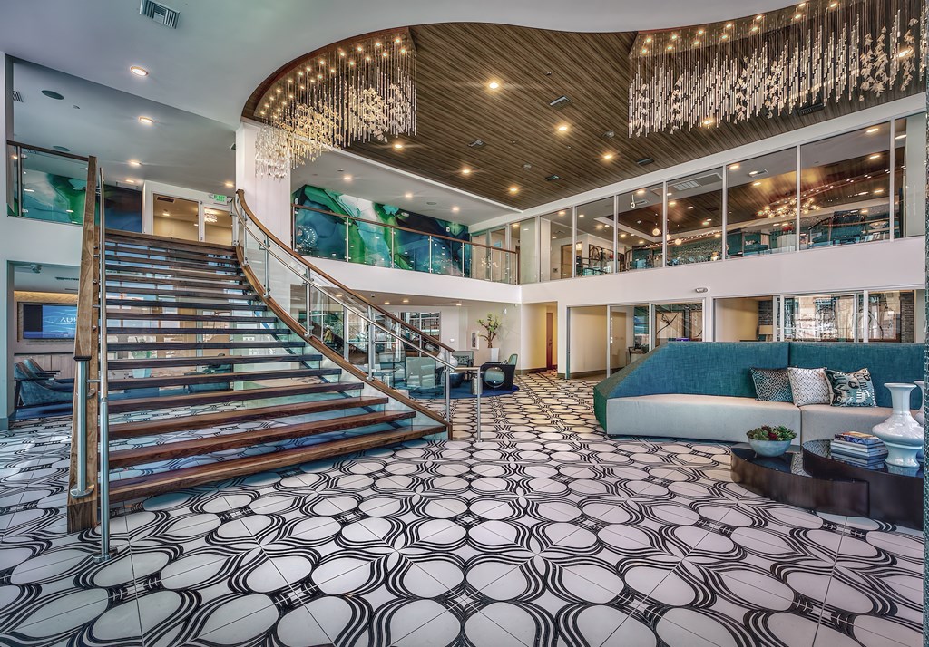 A large, open-concept living space with a staircase and a patterned floor.