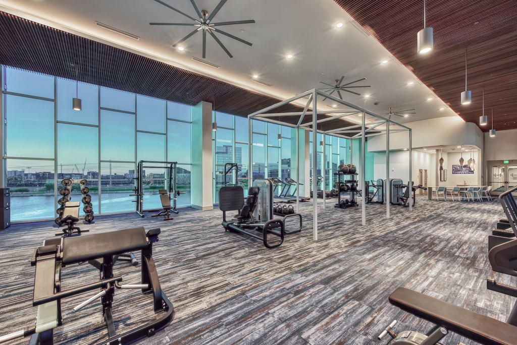 A gym with wooden floors and a variety of exercise equipment.