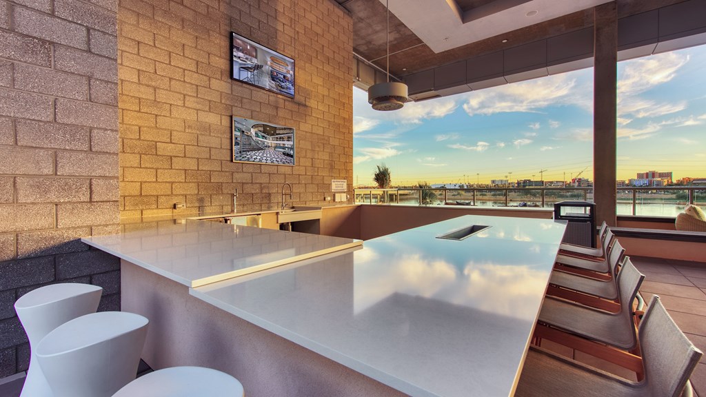 A bar with a view of the city at sunset.