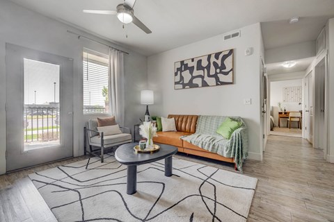 A living room with a grey sofa, a coffee table, and a painting on the wall.