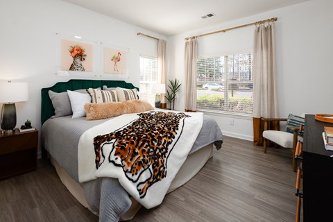 a bedroom with a bed with a leopard blanket