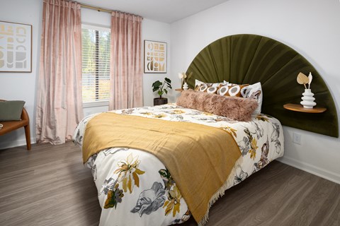 a bedroom with a bed with a green headboard