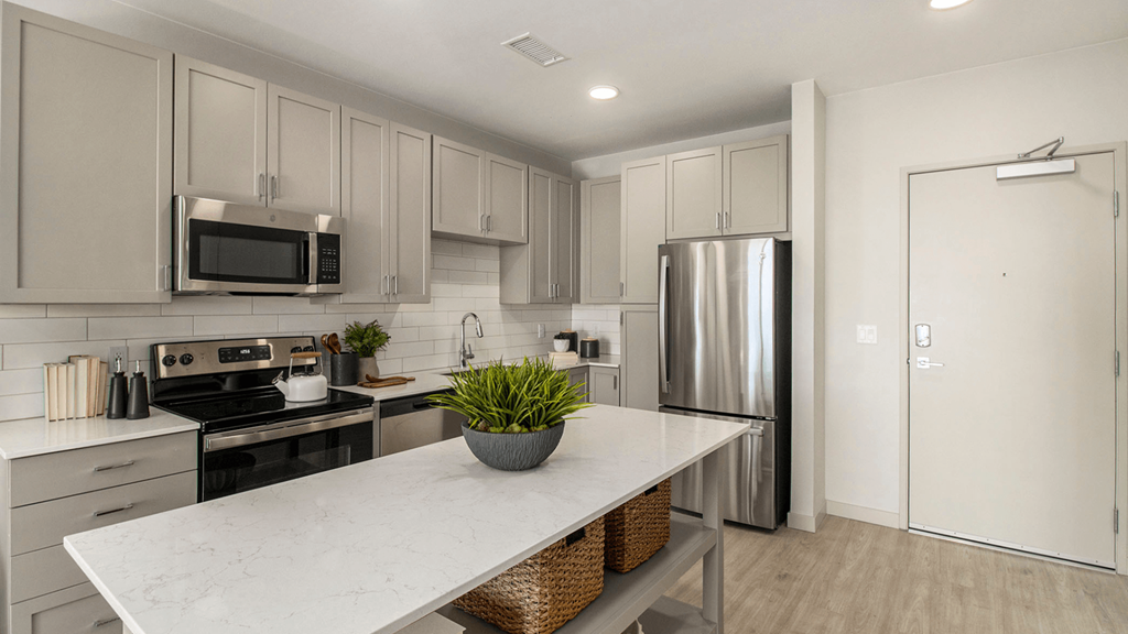 a kitchen with stainless steel appliances and a marble counter top