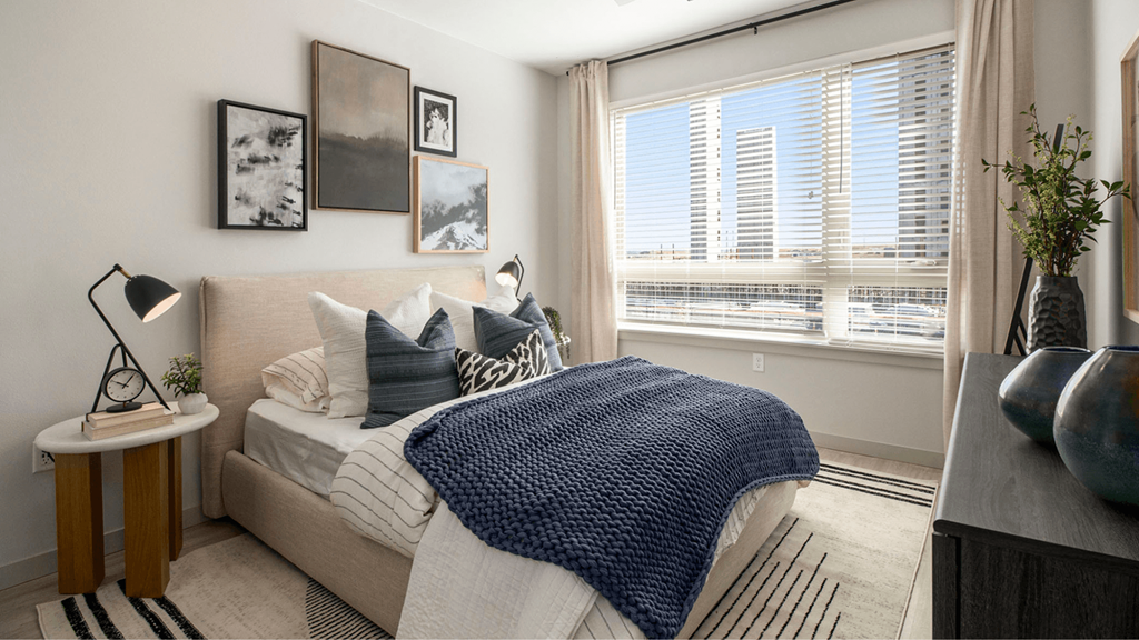 a bedroom with a bed and a large window