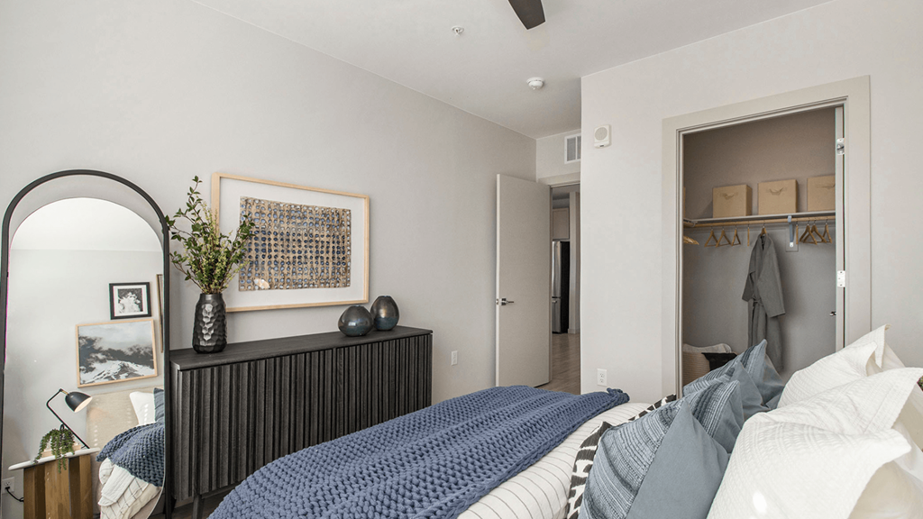 a bedroom with a bed and a dresser and a closet