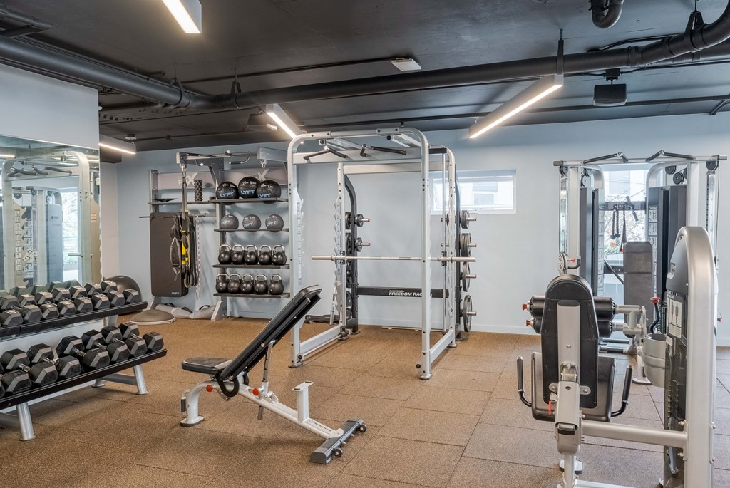 A gym with a variety of equipment including weights and weight machines.at Axle, Seattle, 98119