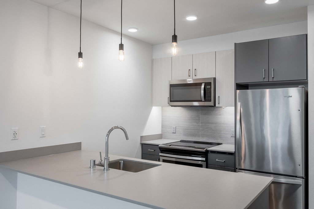 A modern kitchen with a stainless steel refrigerator and a sink with a faucet.at Axle, Washington