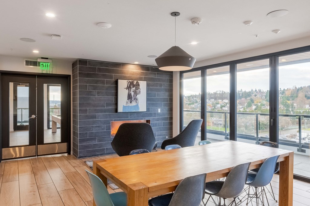A conference room with a long table and chairs, a fireplace, and a view of the outdoors through large windows.at Axle, Seattle, WA