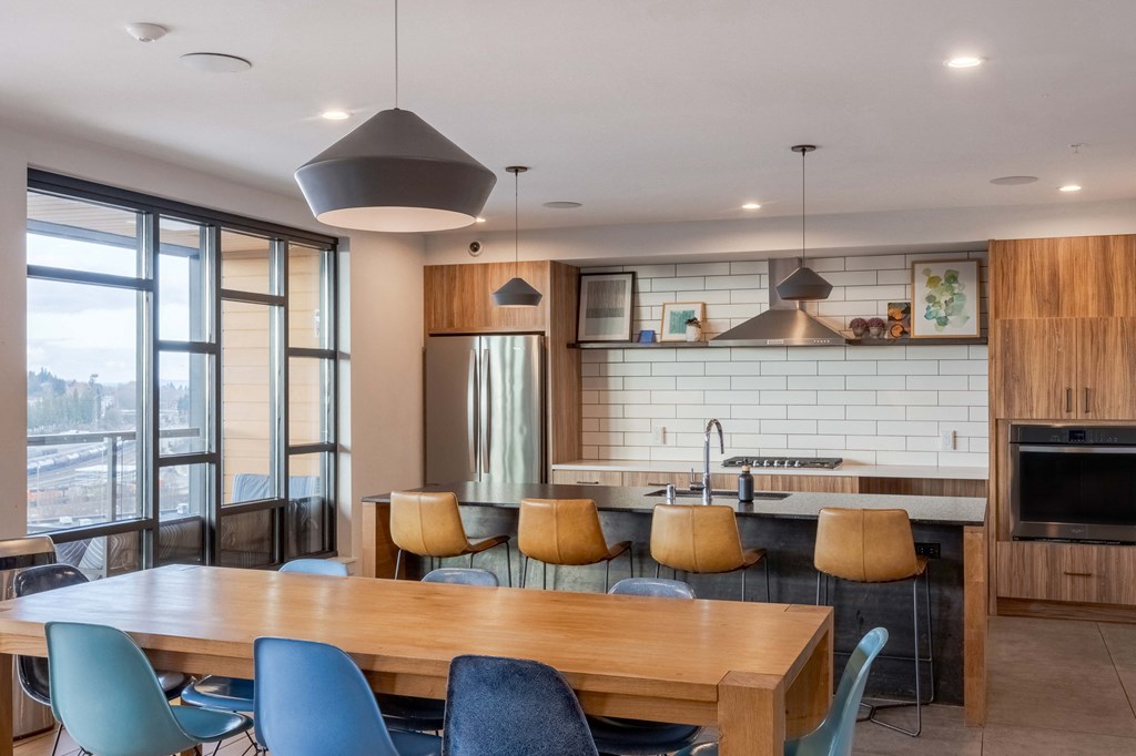A modern kitchen with a large island and a dining table with chairs.at Axle, Seattle, WA 98119
