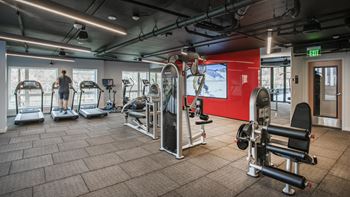 A gym with a variety of equipment including treadmills, weights, and exercise machines.at Axle, Seattle Washington