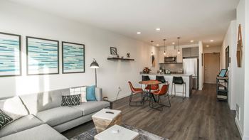 A modern living room with a grey sofa and a wooden dining table.at Axle, Seattle, WA