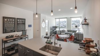 A modern kitchen with a large island and pendant lights.at Axle, Seattle
