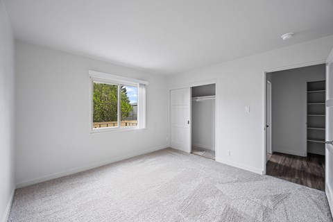A spacious, empty room with a window and a door at Hillsdale Garden Apartments, CA 94403