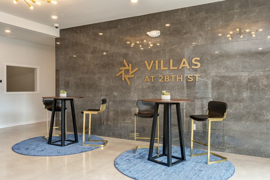 a rendering of the lobby of villas at 28th street with tables and chairs
