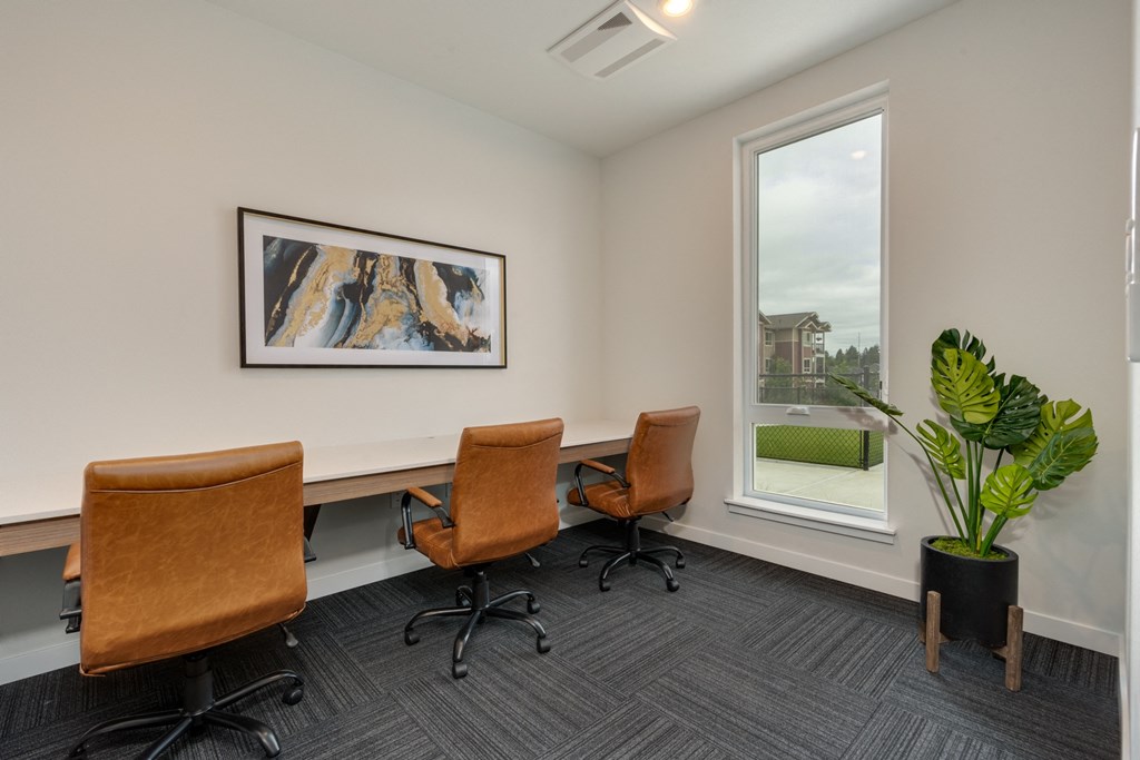 a conference room with four chairs and a desk and a window