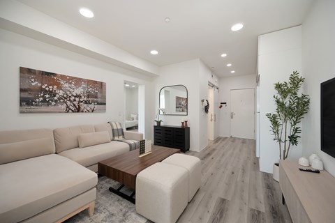 A living room with a couch, a coffee table, and a painting on the wall.