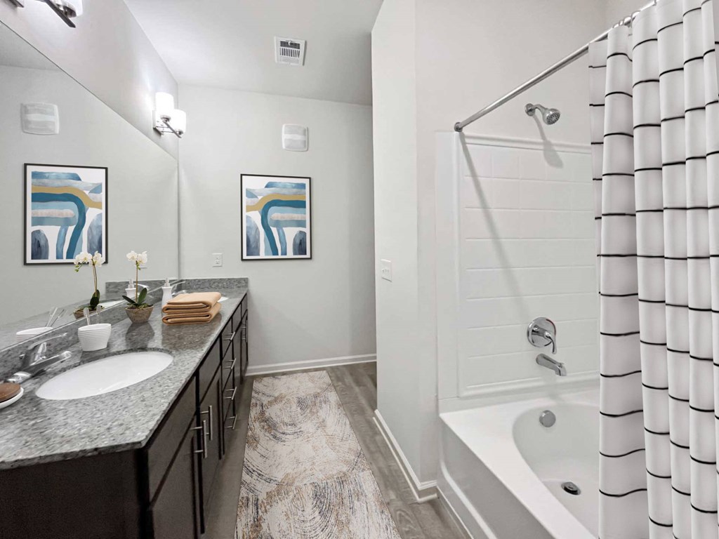 A bathroom with a white tub, a sink, and a shower curtain.