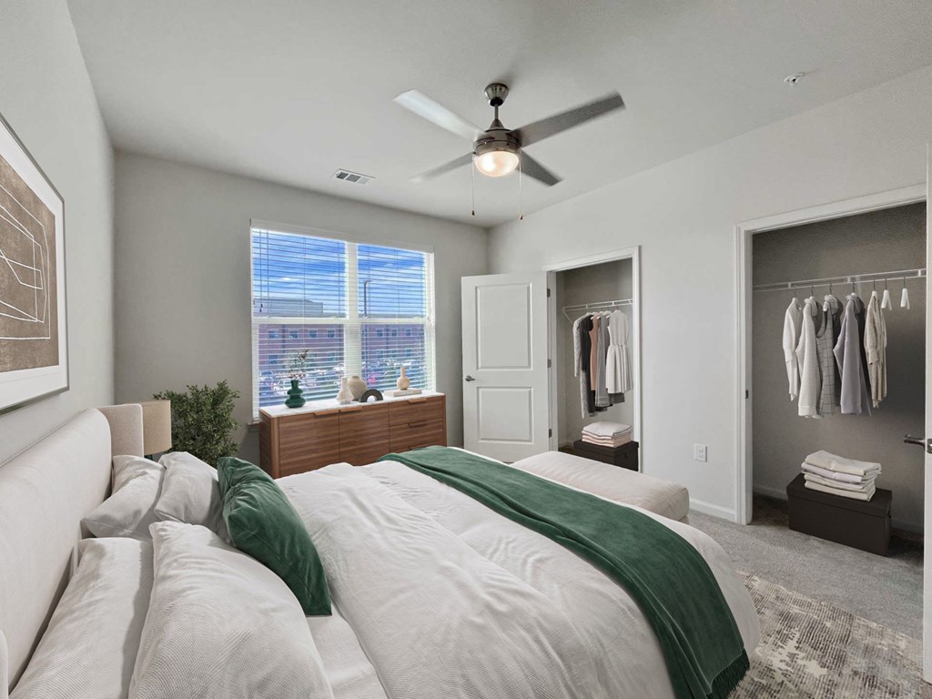 A bedroom with a large bed and a ceiling fan.