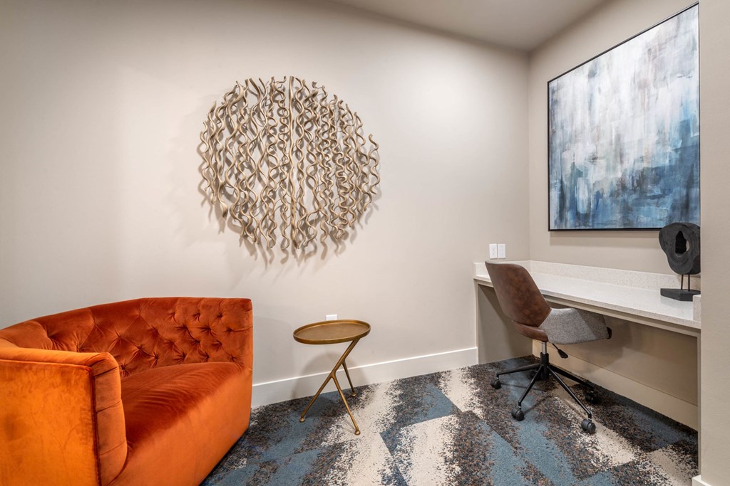 an office with an orange couch and a desk with a chair
