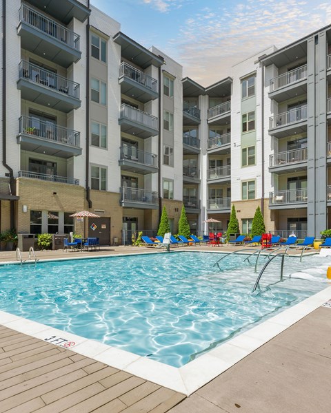 A large swimming pool in front of apartment buildings.