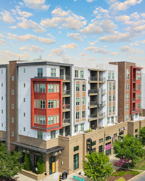 A street view of a city with apartment buildings and a traffic light.