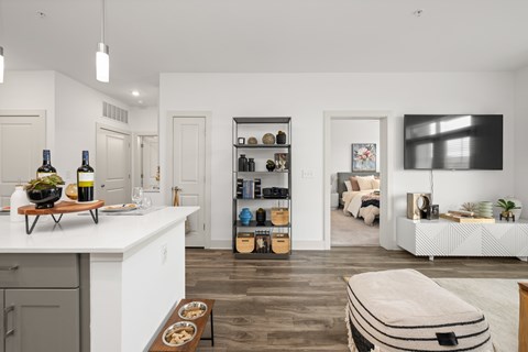 A modern kitchen with white cabinets and a wooden floor.