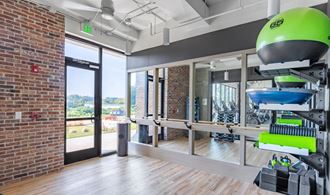 a workout room with weights and a brick wall and a glass door