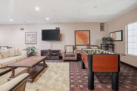 A living room with a pool table and a television.