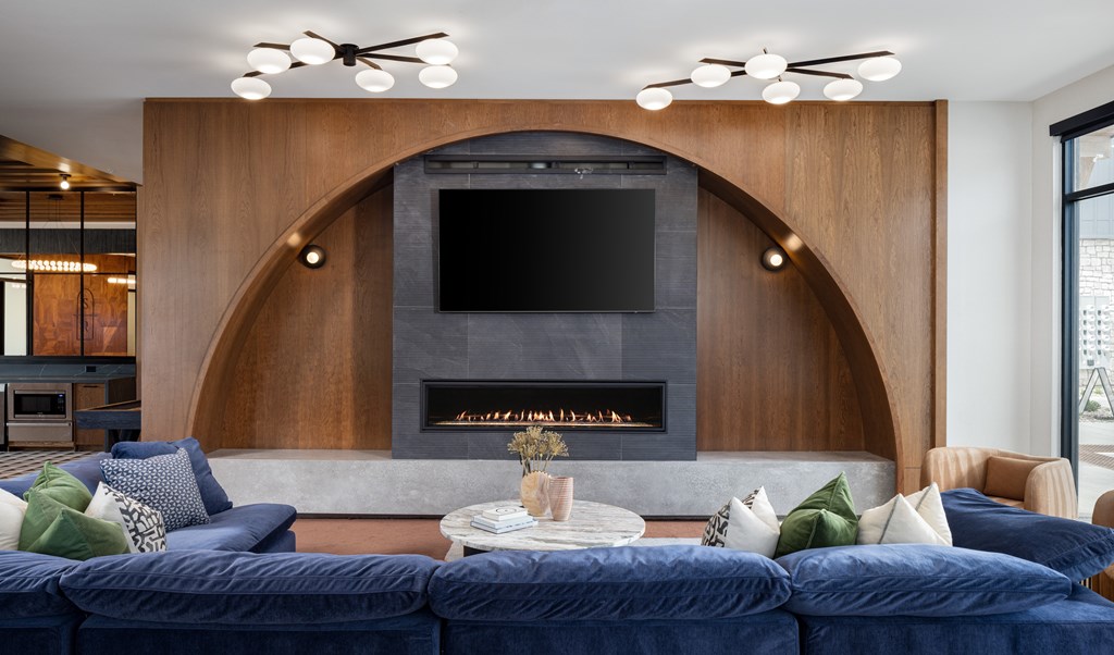 A modern living room with a fireplace and a TV above it.