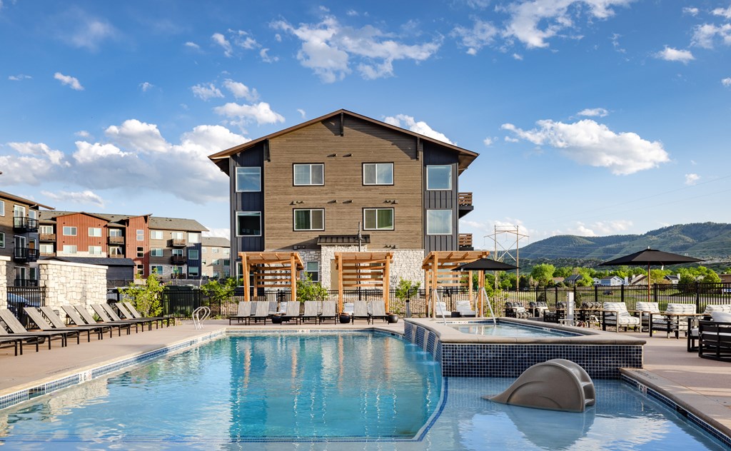 A large wooden building with a pool in front.