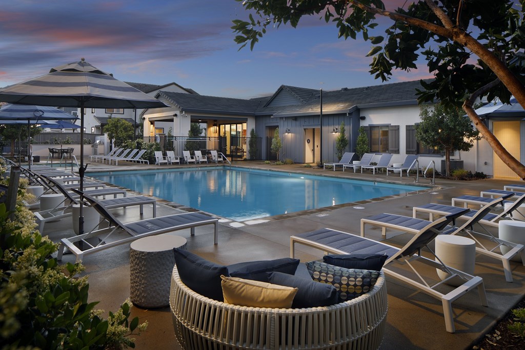 A poolside area with lounge chairs and a sunbed.