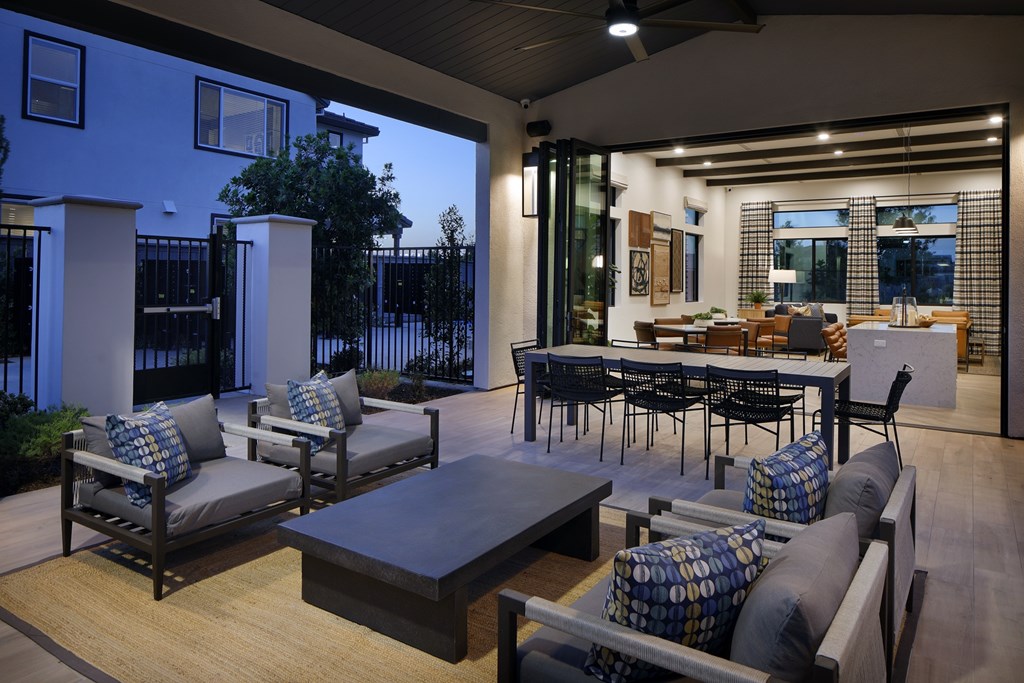 A patio with a table and chairs is set up outside a house.