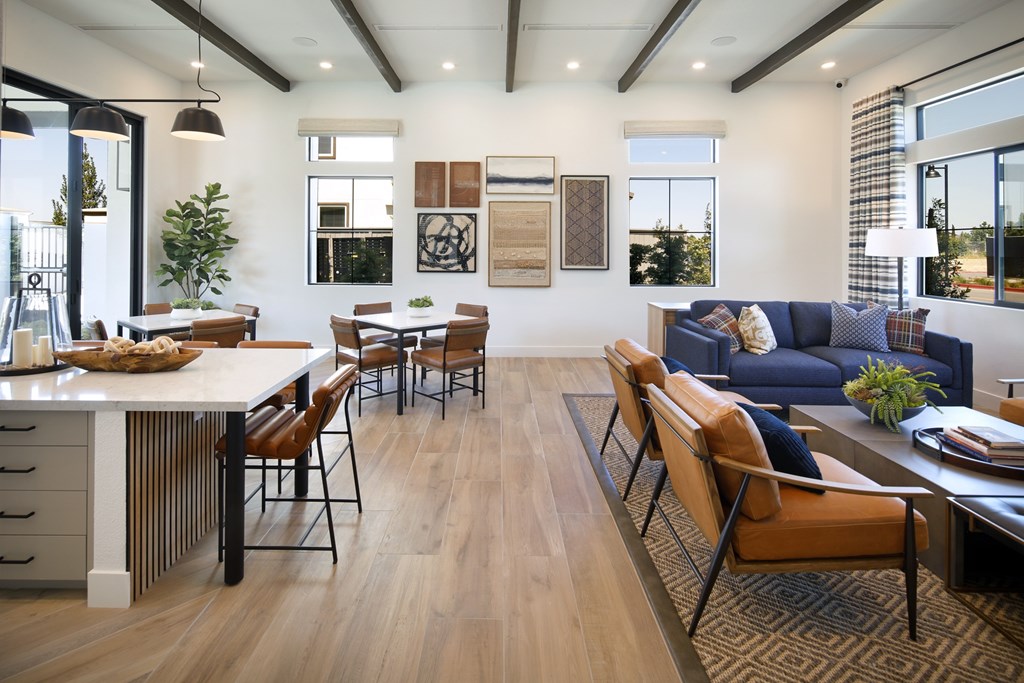 A modern living room with a white dining table and brown chairs.
