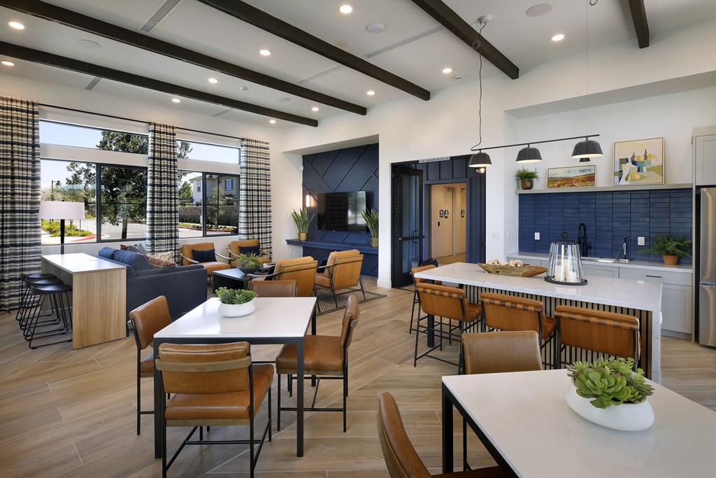 A modern kitchen and dining area with wooden floors and furniture.