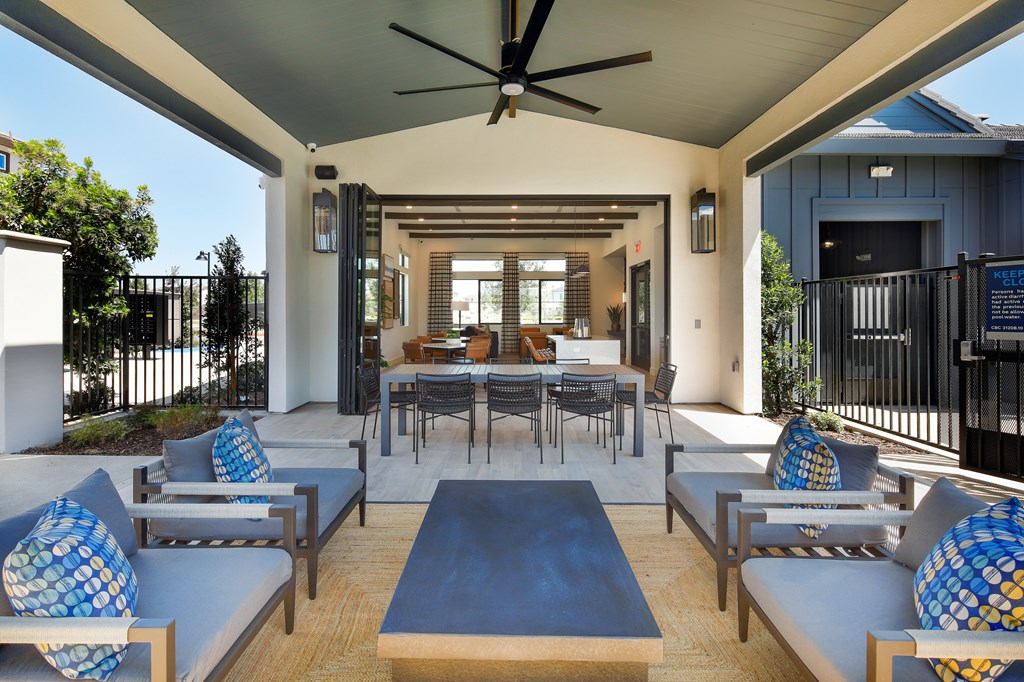 A patio with a table and chairs is covered by a roof.