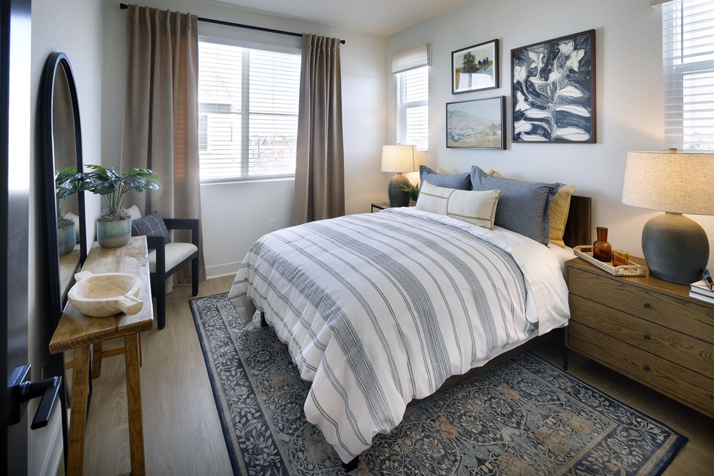 A bedroom with a large bed and a mirror on the wall.