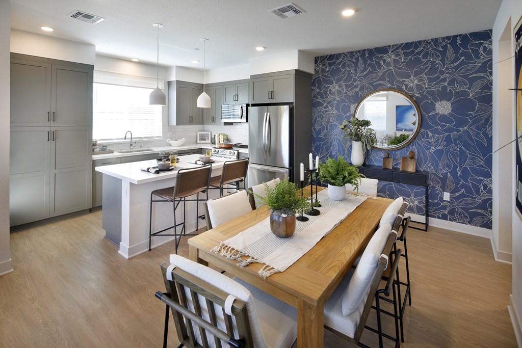 A modern kitchen with a dining table set for two.