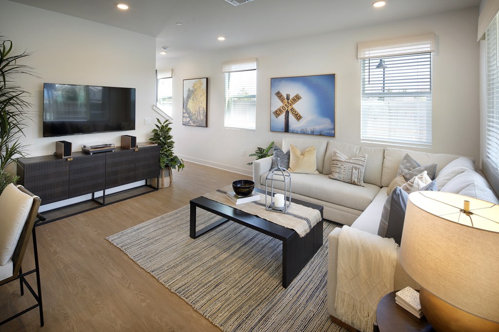 A living room with a couch, a chair, a coffee table, and a television.