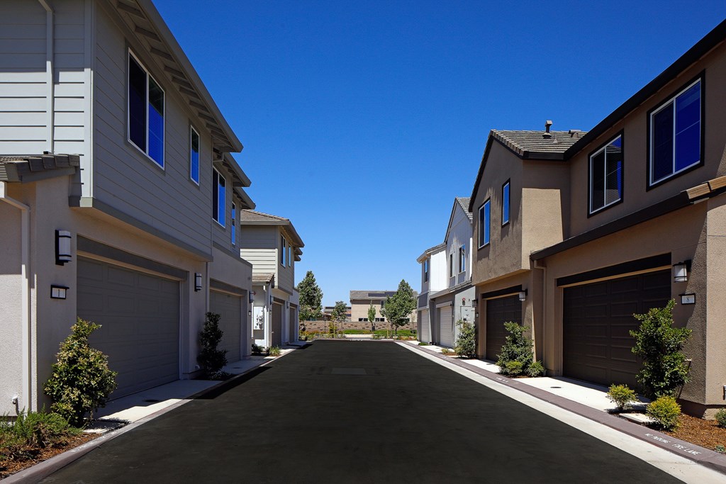 A row of houses with garages on the side.